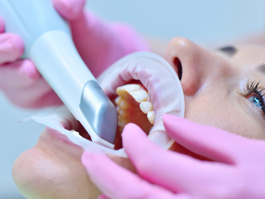 Dentist scanning patient's teeth with 3D scanner