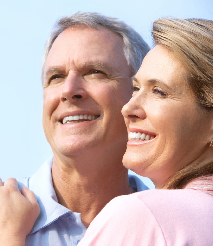 Elderly couple smiling with dental implants in Montreal