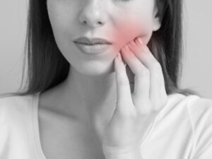 Young woman experiencing a toothache in closeup