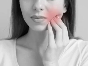 Young woman experiencing a toothache in closeup