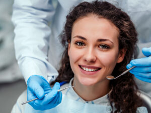 Dentist examining a girl's teeth with dental tools