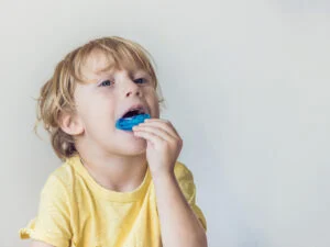 Three-year-old boy demonstrates myofunctional trainer for mouth breathing