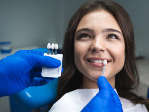 Dentist applying tooth enamel shade to patient’s teeth