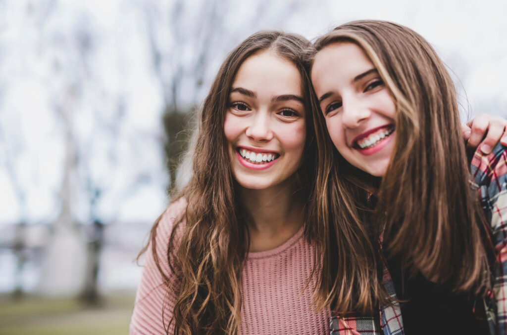 Teen girl with long hair smiling in urban setting