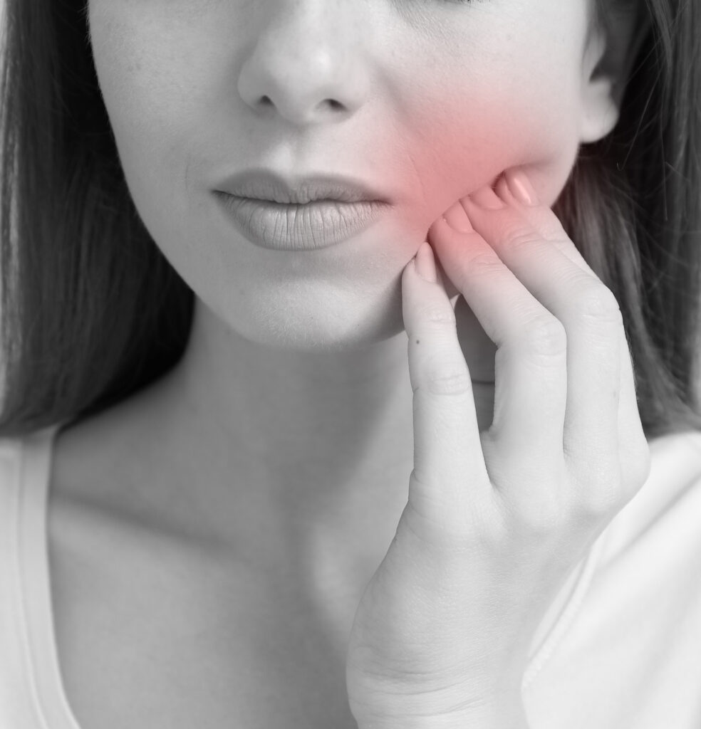 Closeup of young woman experiencing severe toothache